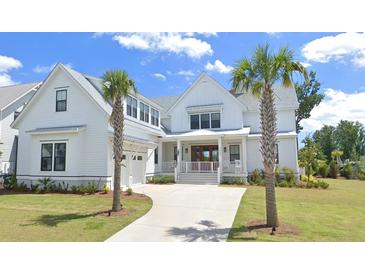 Inviting two-story home with a manicured lawn, attached garage, and a welcoming front porch at 3807 Sawyers Island Dr, Mount Pleasant, SC 29466