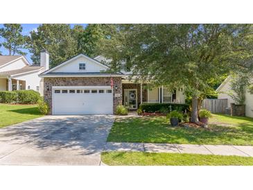 Charming home featuring a stone facade, manicured lawn, and a two-car garage at 404 Norwood Ct, Moncks Corner, SC 29461