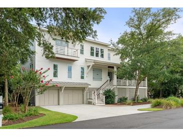 Beautiful multi-story home with a three-car garage and lush landscaping enhancing its curb appeal at 55 Seagrass Ln, Isle of Palms, SC 29451