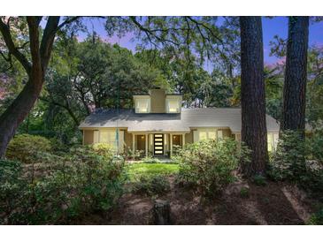 Inviting exterior of a home with a well-manicured lawn and lush landscaping provides privacy at 1052 Yorktown Dr, Charleston, SC 29412