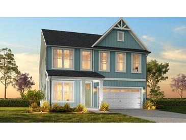 Charming two-story home featuring a blue exterior, a well-manicured lawn, and an attached two-car garage at 1219 Homecoming Blvd # Cc1-27, Ravenel, SC 29470