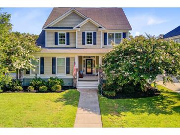 Charming two-story home with a well-manicured lawn, flowering trees, and welcoming front porch at 173 Silver Cypress Cir, Summerville, SC 29485
