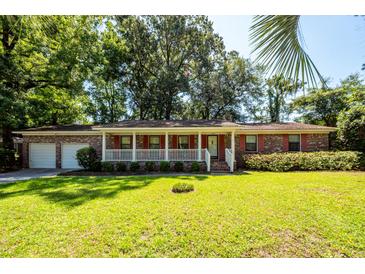 Charming brick home with a white picket fence and a well-manicured green lawn at 2320 Wofford Rd, Charleston, SC 29414