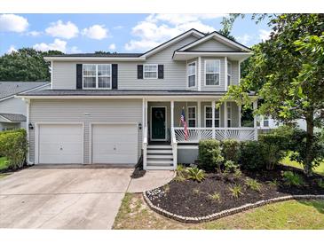 Charming two-story home boasts a welcoming porch, well-maintained lawn, and a two-car garage at 3038 Penny Ln, Johns Island, SC 29455