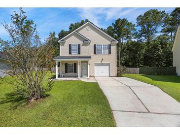 Charming two-story home with well-manicured lawn and inviting front porch at 307 Wilderland Ct, Moncks Corner, SC 29461