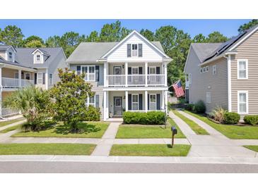Charming two-story home featuring a double front porch, well-manicured lawn, and traditional American flag at 578 Delafield Dr, Summerville, SC 29483