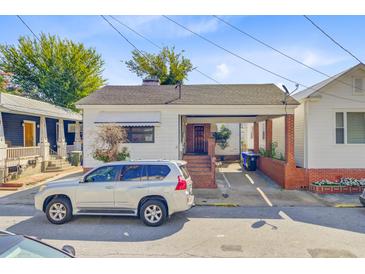 Charming single-story home with a brick and white facade and a convenient covered parking area at 6 Dewey St, Charleston, SC 29403