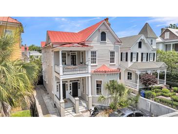 Charming two-story home with a red roof, double porches, and lush greenery at 68 Vanderhorst St # A, Charleston, SC 29403