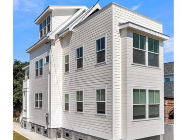 Charming home showcasing light-colored siding and contrasting trim under a bright blue sky at 101 Hanover St, Charleston, SC 29403