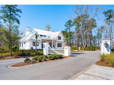 Beautiful exterior shot of a two-story home with a white metal roof and black trim and white picket fence at 105 Peninsula Dr, Ravenel, SC 29470