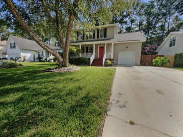 Charming two-story home with landscaped front yard, mature tree, and inviting red front door at 120 Apache Dr, Summerville, SC 29483