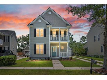 Charming two-story home features a welcoming porch and balcony with nicely manicured landscaping at 1844 Hubbell Dr, Mount Pleasant, SC 29466