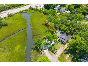 Aerial view of charming home nestled among lush trees, with water views and nearby highway access at 1915 Quitman St, North Charleston, SC 29405
