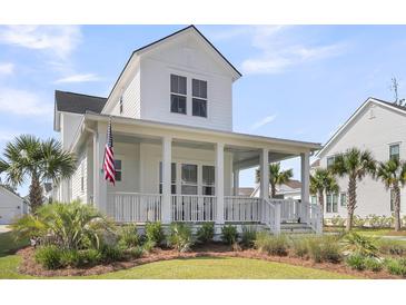 Charming two-story home boasts a welcoming front porch, lush landscaping, and a patriotic American flag at 3769 Summerton St, Mount Pleasant, SC 29466