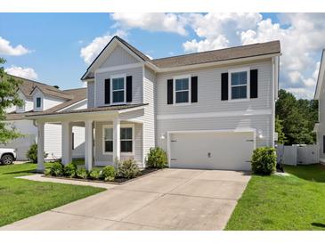 Charming two-story home featuring a two car garage, black shutters and a well manicured lawn at 425 W Respite Ln, Summerville, SC 29483
