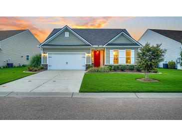Charming single-story home featuring a well-manicured lawn, a red front door, and an attached two-car garage at 554 Tidewater Chase Ln, Summerville, SC 29486