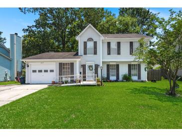 Charming two-story home featuring a well-manicured lawn, inviting front porch, and classic architectural details at 8475 N Scotts Mill Dr, North Charleston, SC 29420