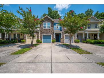 Charming townhomes with stone accents, vibrant doors, and well-manicured front yards and driveways at 854 Bibury Ct, Charleston, SC 29414