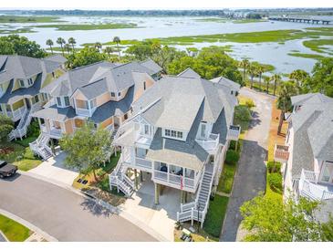 Beautiful two-story coastal home featuring white railings, gray shingles, and elevated design for stunning curb appeal at 1621 Folly Creek Way # D-8, Charleston, SC 29412