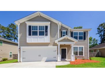 Charming two-story home features a two-car garage, neutral siding, and inviting front porch at 167 Meadow Wood Rd, Summerville, SC 29486
