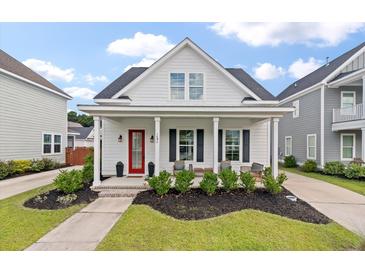 Charming home featuring a covered front porch with stylish landscaping and a striking red front door at 1894 Brittlebush Ln, Johns Island, SC 29455