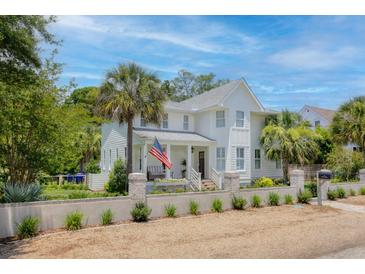 Charming two-story home with a brick wall, front porch, and an American flag at 216 Freeman St, Mount Pleasant, SC 29464