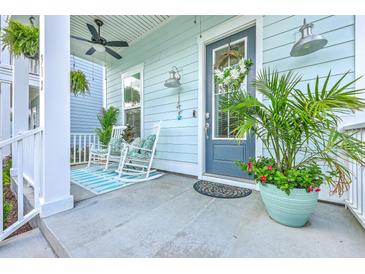 Inviting front porch with rocking chairs, ceiling fan, and decorative plants offering a relaxing outdoor space at 312 Cypress Knee Landing, Summerville, SC 29483