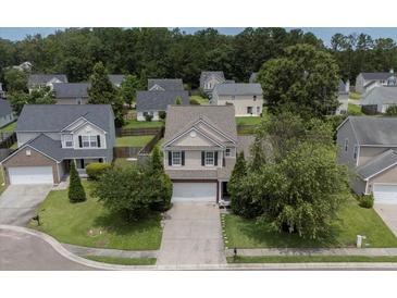 Two-story home with manicured lawn, driveway, and mature trees in a residential neighborhood at 406 Brookfield Ln, Goose Creek, SC 29445