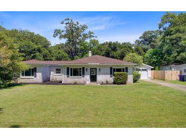 Charming single-story home with a lush green lawn and traditional architectural details at 422 Geddes Ave, Charleston, SC 29407