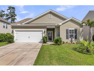 Charming single-story home with a well-manicured lawn, attached garage, and inviting front porch at 519 Tarleton Dr, Summerville, SC 29483