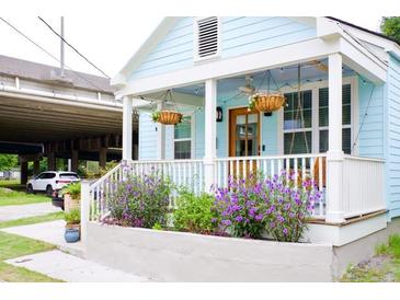 Charming exterior of home with light blue siding, white trim, and flowering plants at 10 Riker St, Charleston, SC 29403