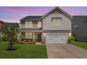 Charming two-story home featuring a well-manicured lawn, stone accents, and a two-car garage at 364 Deep River Rd, Summerville, SC 29486