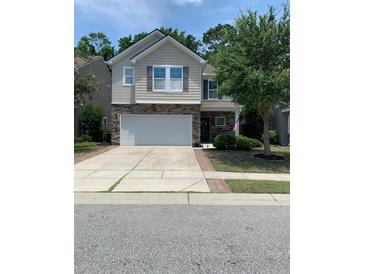 Charming two-story home with a stone-accented facade, attached two-car garage, and well-maintained front yard at 3808 Tupelo Branch Row, Mount Pleasant, SC 29429