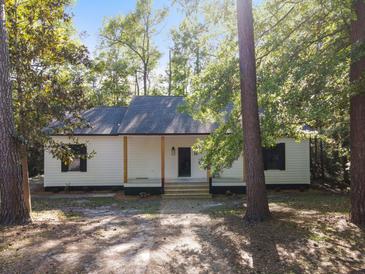 Charming single-story home with a covered front porch and beautiful natural landscaping at 406 Center St, Walterboro, SC 29488