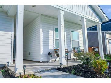 Inviting front porch with stylish seating and well-manicured landscaping adds curb appeal to this charming home at 4407 Palm Shadow Dr, Summerville, SC 29485