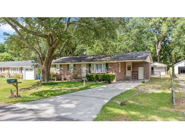 Charming brick home with green shutters, a well-manicured lawn, and a long concrete driveway at 4767 June St, North Charleston, SC 29405