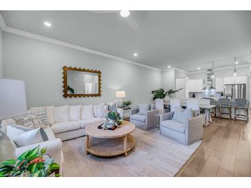 Bright living room featuring hardwood floors, a ceiling fan, and comfortable seating at 7414 Indigo Palms Way, Johns Island, SC 29455