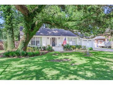 Charming single-story home with a lush green lawn and mature trees offering plenty of shade at 938 Sea Gull Dr, Mount Pleasant, SC 29464