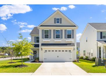 Charming two-story home with a white garage door and beautiful landscaping at 101 Guernsey Ln, Summerville, SC 29483