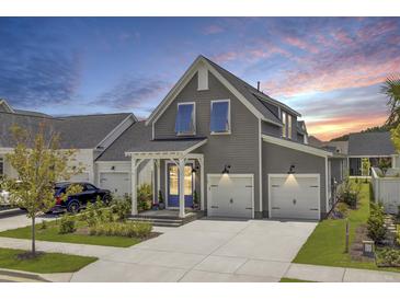 Beautiful two-story gray home with blue shutters, a welcoming porch, and a two-car garage at 110 True Blue Lp, Summerville, SC 29486