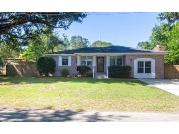 Charming brick home with well-maintained lawn, mature trees, and an American flag at 1261 Hampshire Rd, Charleston, SC 29412