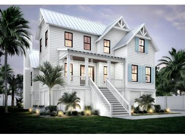 Beautiful two-story home featuring a classic design, inviting front porch, and well-maintained landscaping at 1727 Atlantic Ave, Sullivans Island, SC 29482