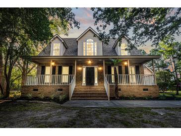 Charming brick home with a welcoming front porch, perfect for relaxing and enjoying the outdoors at 3385 Wayland Dr, Ladson, SC 29456