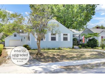 Charming light blue two-story home with landscaped yard, mature trees, and detached garage at 4756 Churchill Rd, North Charleston, SC 29405