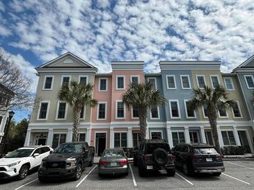 Charming townhomes boast vibrant, pastel exteriors complemented by lush palm trees and convenient parking at 656 Coleman Blvd # 402, Mount Pleasant, SC 29464