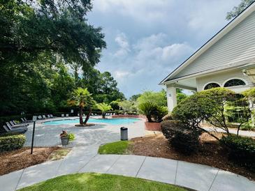 Enjoy the community pool, surrounded by lush landscaping and comfortable lounge chairs at 700 Daniel Ellis Dr # 2203, Charleston, SC 29412