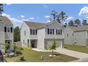 Charming two-story home featuring a well-maintained front yard, stone accents, and a welcoming entrance at 138 Sweet Cherry Ln, Summerville, SC 29486