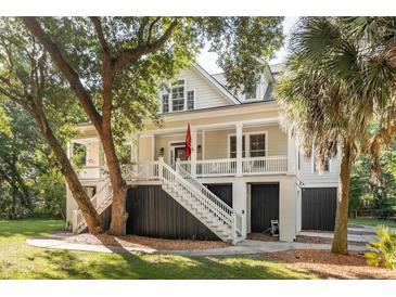 Charming coastal home featuring a welcoming front porch, white railings, and lush landscaping at 2911 Old Tavern Ct, Mount Pleasant, SC 29466