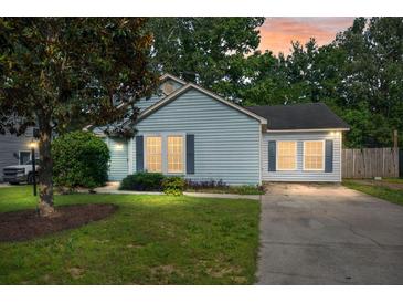 Charming single-story home featuring a well-manicured lawn and inviting curb appeal at dusk at 8108 Halifax Way, North Charleston, SC 29420