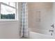 Clean bathroom with a white bathtub, marble tile, and a window at 173 Fiddleback Dr, Summerville, SC 29486